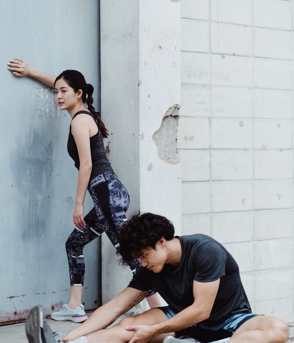 Athletic woman performing dynamic stretching exercises in a modern studio